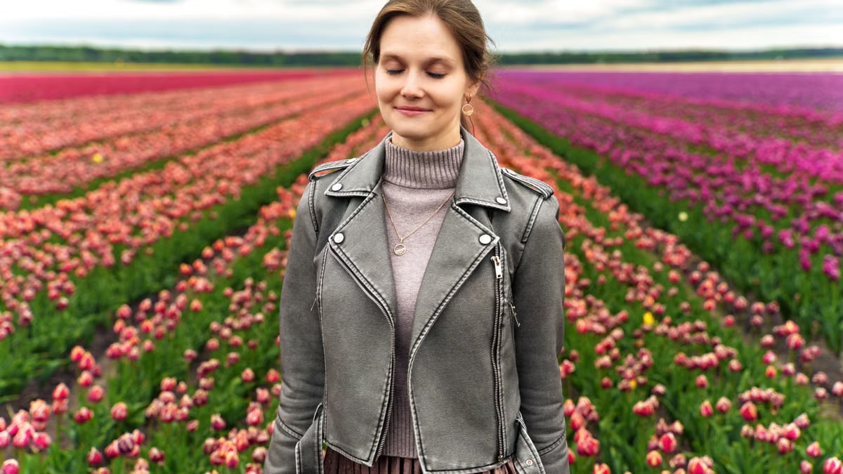 A woman enjoys a peaceful moment amid a colorful tulip field in spring.